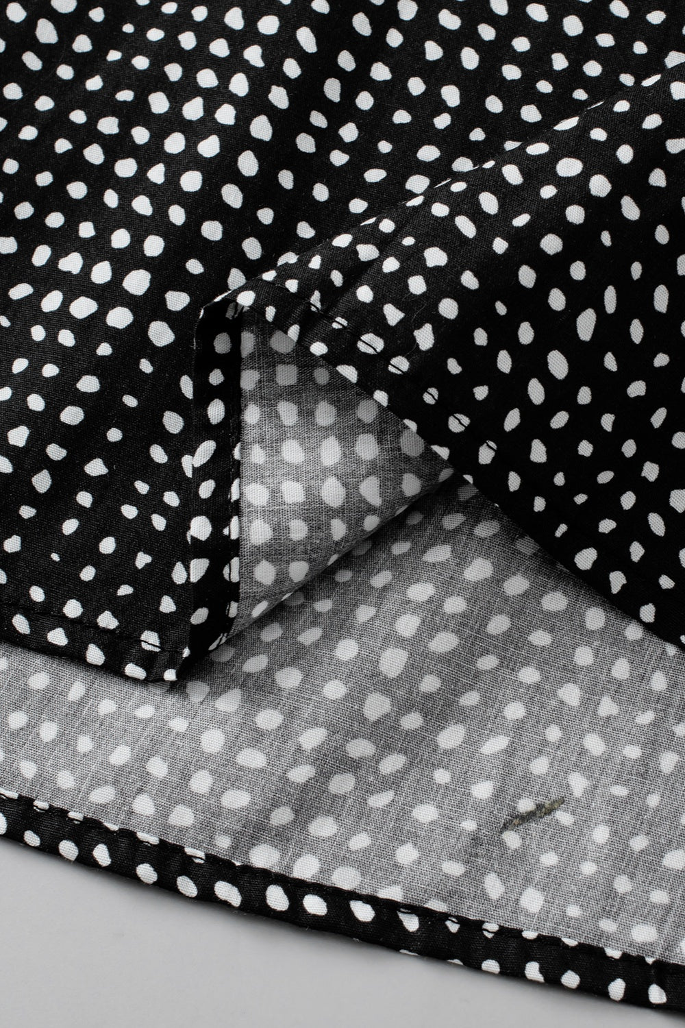 Black micro-dot puff sleeve blouse with a casual, basic style.