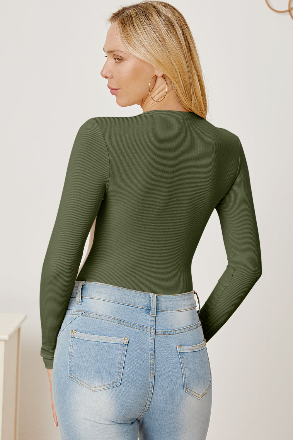 Ribbed long sleeve bodysuit in Matcha Green with a plunge neckline, styled with light wash jeans.