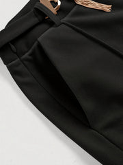 Black flared leg trousers with gold chain detail and pocket.