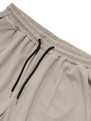 Khaki textured drawstring sweatpants for men with waffle knit fabric and black drawstrings.