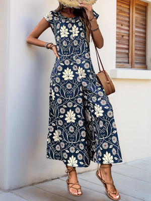 Navy botanical print culotte jumpsuit with short sleeves and round neckline.
