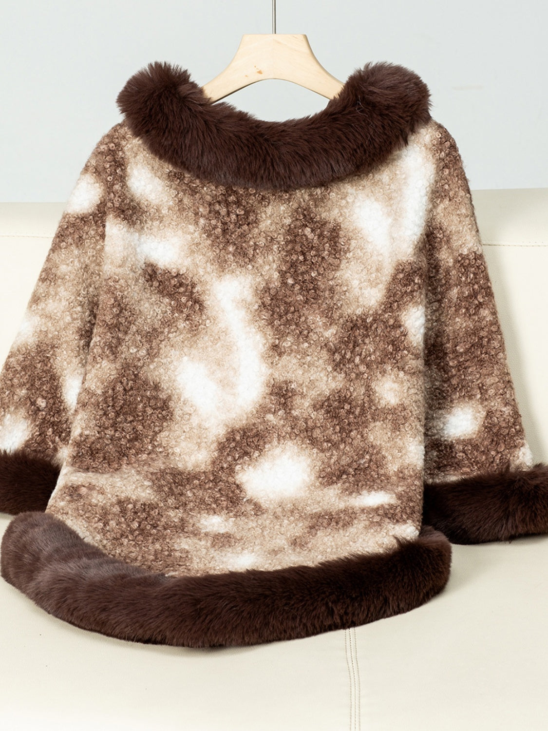 Faux fur trimmed camo poncho in chocolate brown with a fuzzy texture and a relaxed fit.