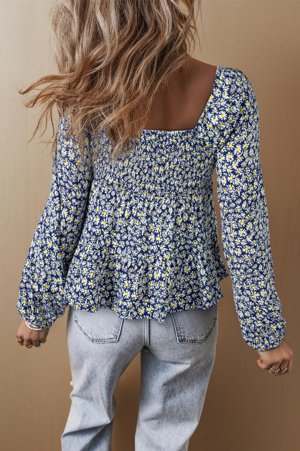 Daisy print peplum blouse in dusty blue with smocked bodice and square neckline.