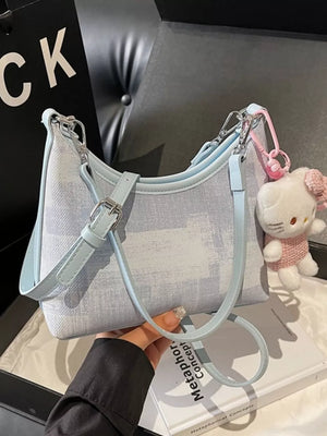 Blue crescent mini shoulder bag with Hello Kitty charm and light blue trim.
