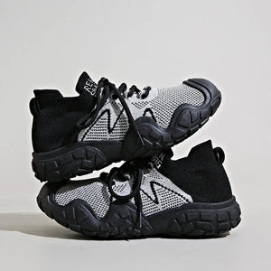 Black knit athleisure sneakers with white zigzag detail and chunky soles.