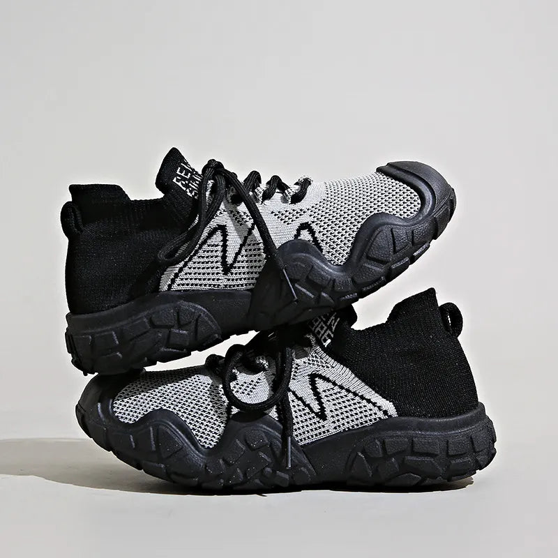 Black knit athleisure sneakers with white zigzag detail and chunky soles.