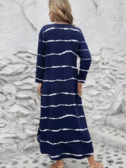 Maxi dress with abstract white stripes on navy blue, V-neck, long sleeves, and a relaxed fit.