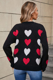 Black crewneck knit pullover with allover red and white heart motif.