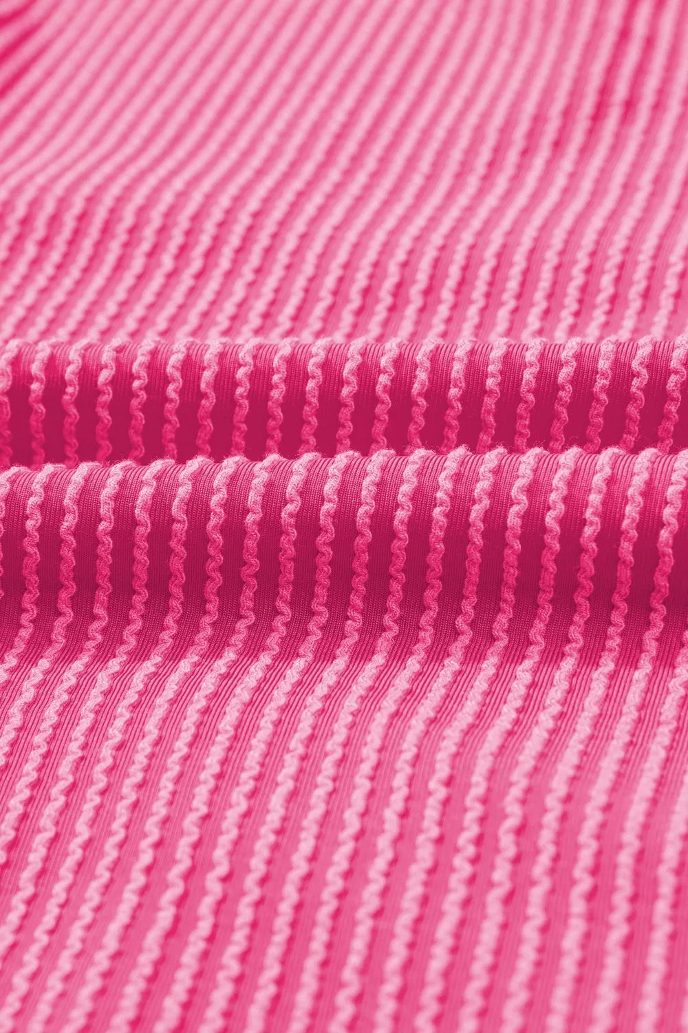 Pink ribbed maternity t-shirt with a textured pattern and a backless detail.