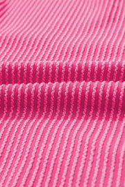 Pink ribbed maternity t-shirt with a textured pattern and a backless detail.