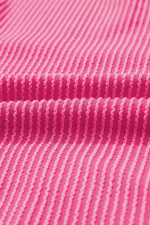 Pink ribbed maternity t-shirt with a textured pattern and a backless detail.