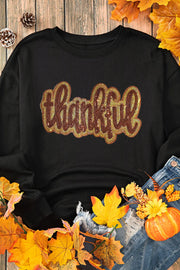 Black crewneck sweatshirt with sequin "thankful" graphic.