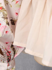 Charming ruffled floral mini dress with a light pink floral print and sheer overlay.