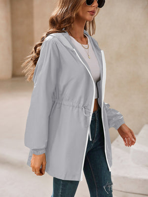 Gray hooded jacket with cinched waistline and white zipper detail.