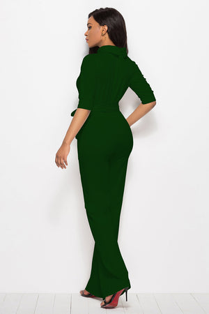 Dark green belted palazzo jumpsuit with high neckline and three-quarter sleeves.