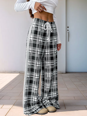 Plaid wide-leg track pants in black with white side stripe and drawstring waist.