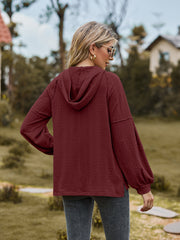 Textured knit hoodie in wine with balloon sleeves and cable pattern.