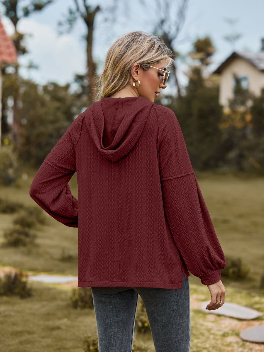 Textured knit hoodie in wine with balloon sleeves and cable pattern.