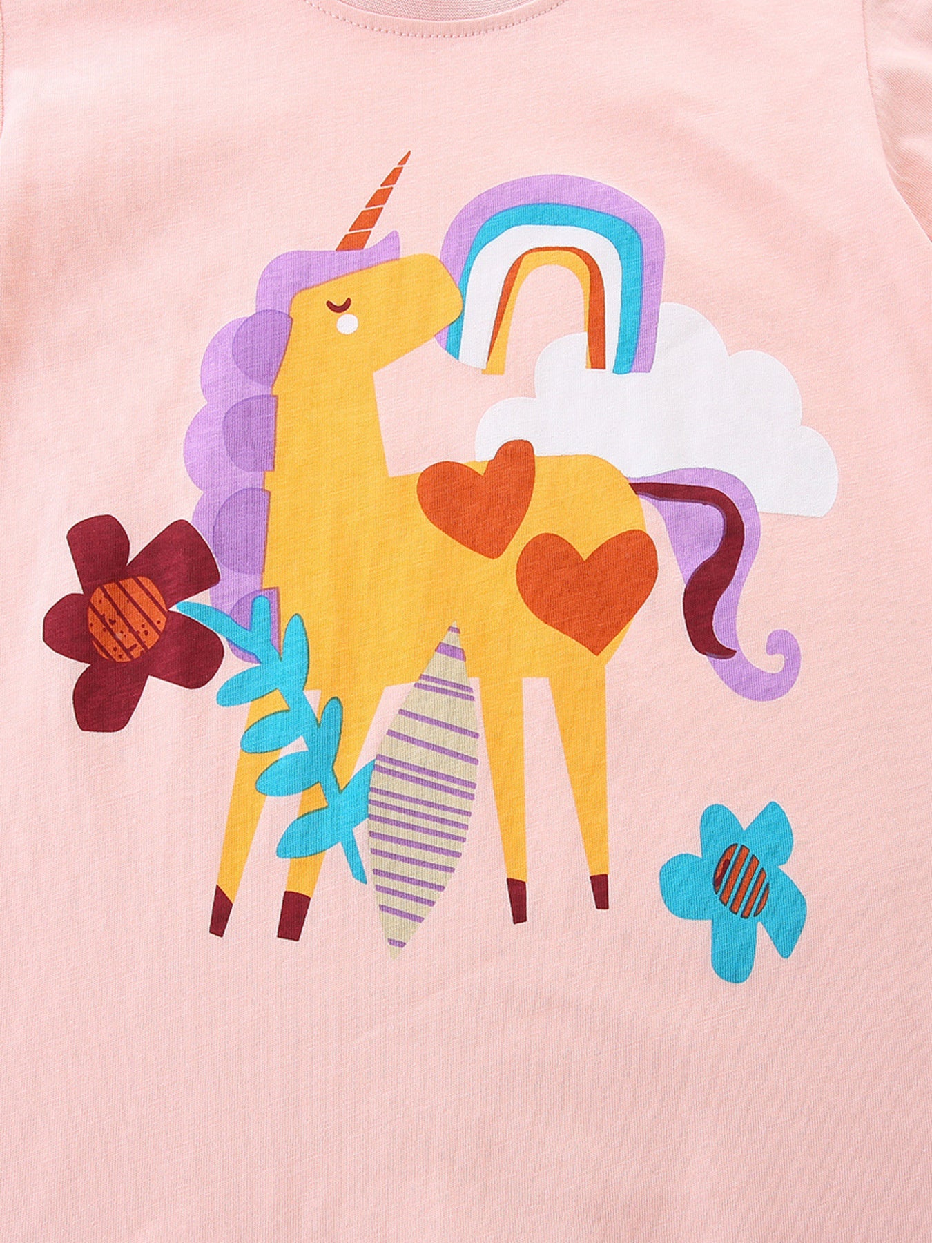 Children's blush pink cotton t-shirt with a yellow unicorn, rainbow, and flowers graphic.