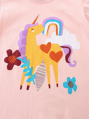Children's blush pink cotton t-shirt with a yellow unicorn, rainbow, and flowers graphic.