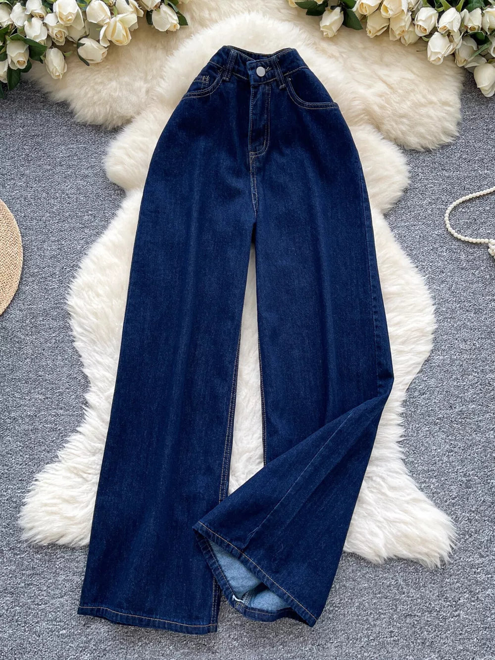 Dark wash denim maternity jeans with a high rise and wide leg cut.