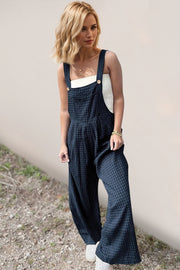Textured wide-leg pinafore jumpsuit in peacock blue with button details and a square neckline.