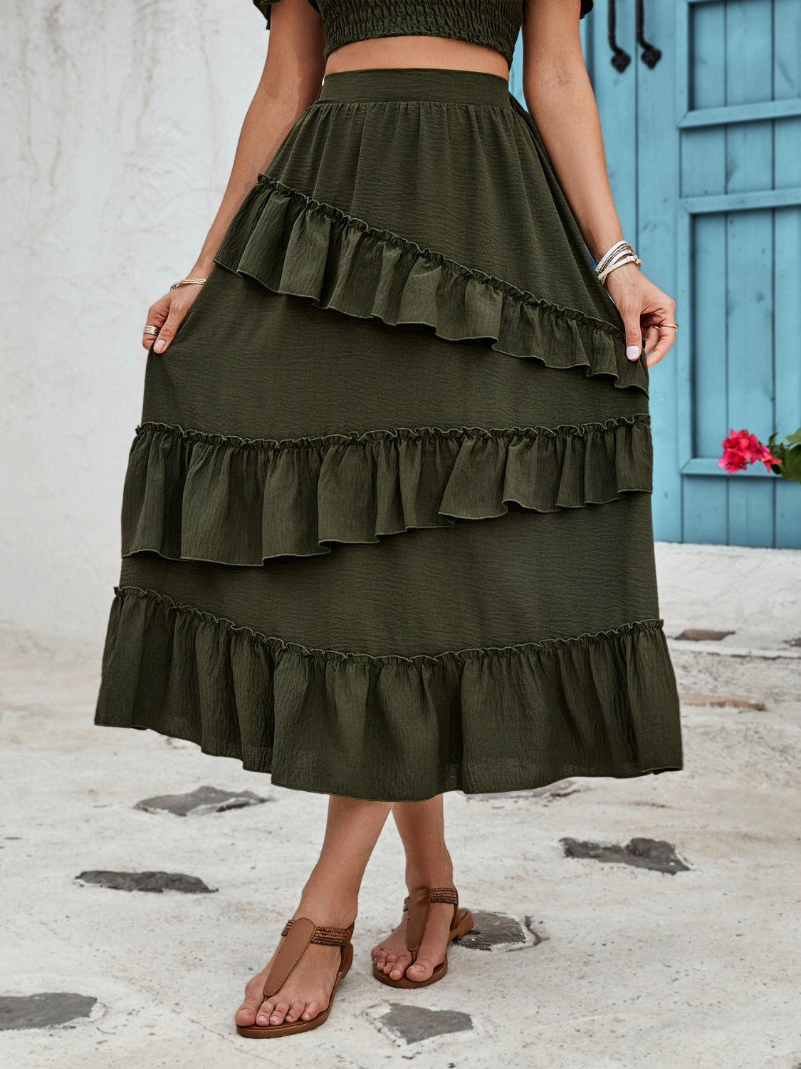 Tiered midi skirt in dark green with ruffled tiers and textured fabric.