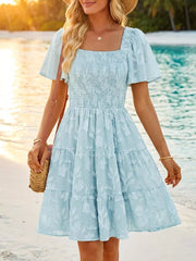 Light blue smocked mini dress with tiered skirt and floral texture, square neck, puff sleeves