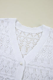 White openwork crochet cardigan with V-neck and pearl button detail.