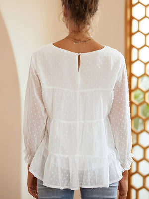 White tiered Swiss dot peasant blouse with long sleeves and ruffled cuffs.