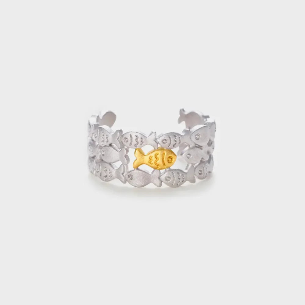 Adjustable ring with a school of silver fish and one gold fish in the center.