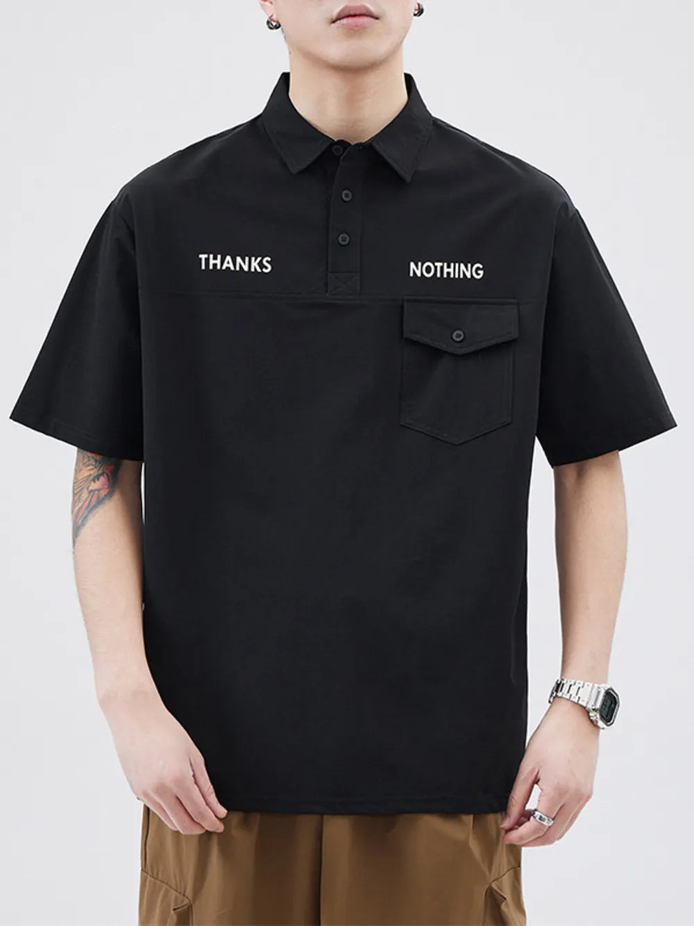 Black short sleeve polo with button detail and chest pocket, featuring white text.