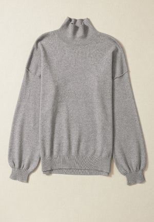 Gray knit sweater with mock neck and balloon sleeves.