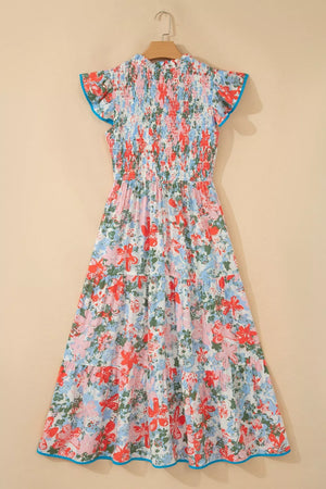 Maxi dress with flutter sleeves, smocked bodice, tiered skirt, and floral print with blue trim.