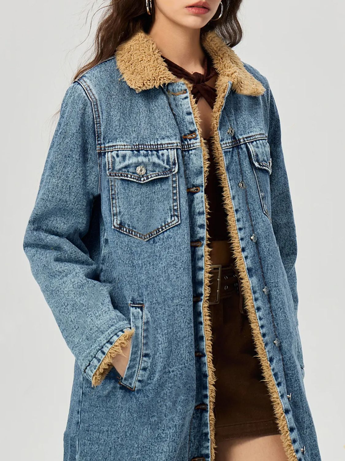 Denim maxi coat in medium wash with shearling trim and button closure.