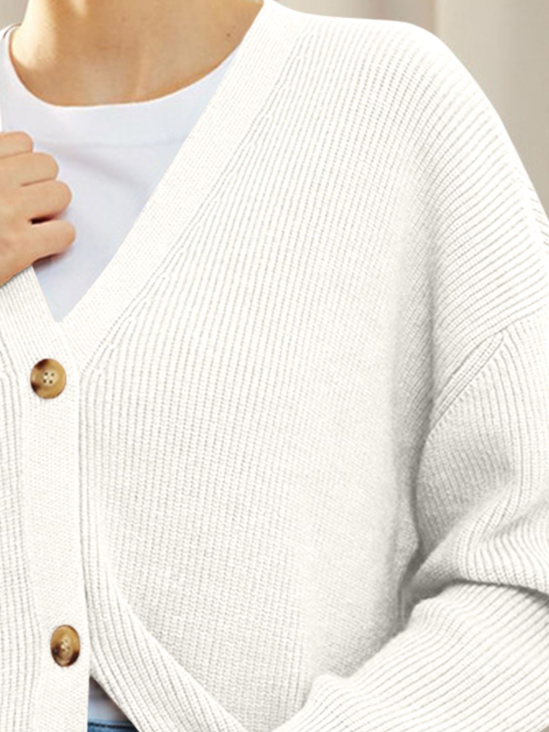 White ribbed knit button cardigan with V-neck and balloon sleeves.