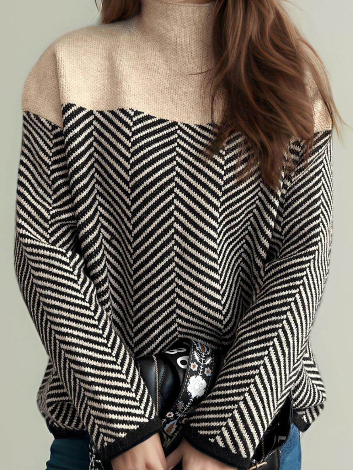 Chevron knit turtleneck sweater with colorblock tan and black chevron pattern.