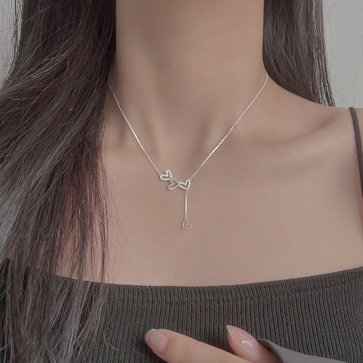 Sterling silver Y-necklace with delicate heart charms and a dangling heart pendant.