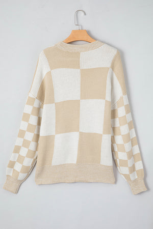 Beige and white checkerboard knit sweater with crewneck and long sleeves.