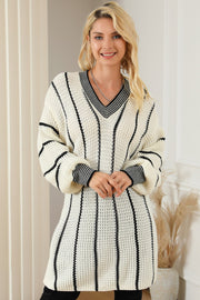 Ivory knit oversized V-neck dress with black vertical stripes and ribbed cuffs.