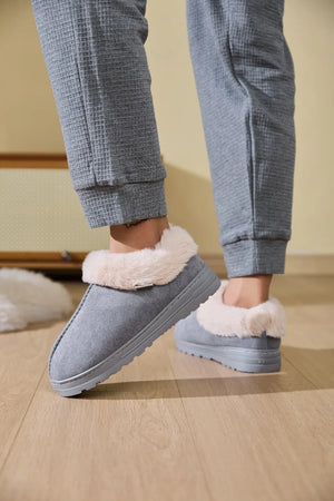 Gray suede shearling-trimmed house slippers with a subtle buckle detail.