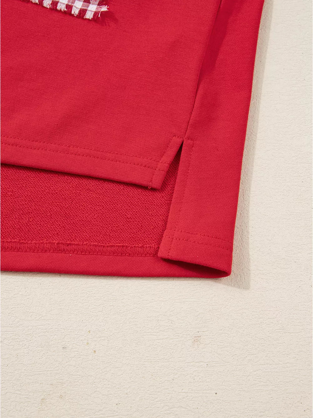 Red cotton sweatshirt with side slits and a festive plaid detail.