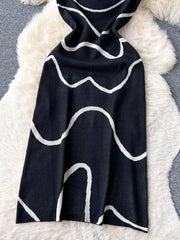 Black wavy knit midi dress with spaghetti straps and abstract white pattern.