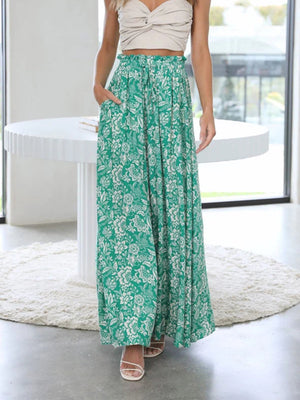 Green palazzo trousers with white floral print and ruffled waist.