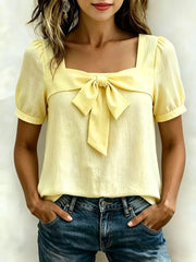 Yellow bow tie puff sleeve shirt with square neckline.