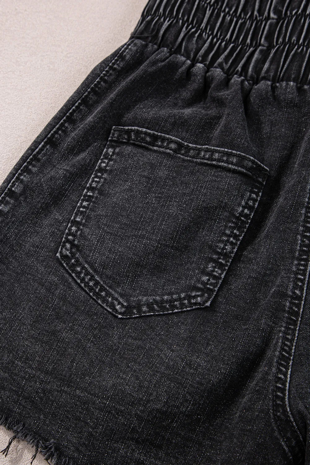 Black denim shorts with elastic waist and frayed hem detail