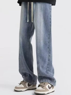 Men's blue oversized fit jeans with drawstring and distressed wash.