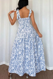 Maxi dress with blue floral print, smocked bodice, and tie straps.