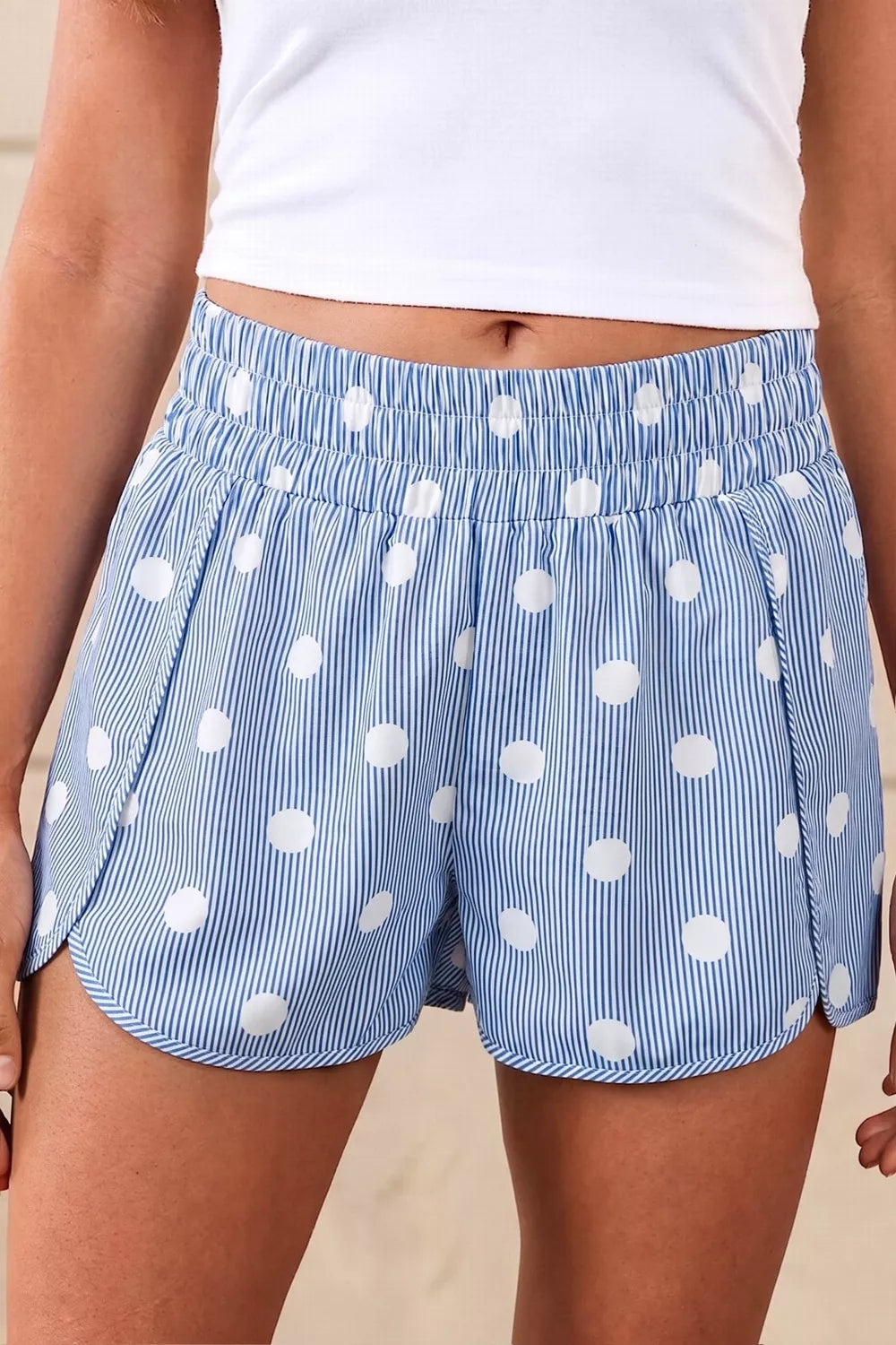 Blue and white striped polka dot shorts with elastic waist and curved hem.