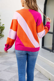 Diagonal colorblock knit sweater in orange and pink acrylic with a crew neck and long sleeves.